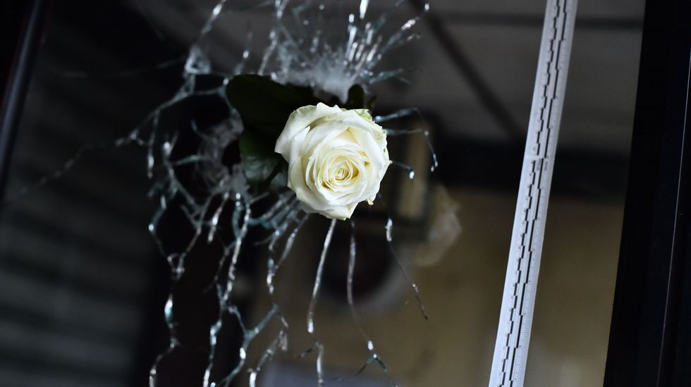 Una rosa colgada a través del agujero de la cristalera de uno de los establecimientos tiroteados en París.