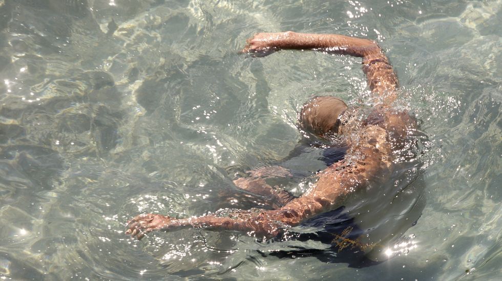 Un hombre se sumergido en el agua en la playa de Riazor, en A Coruña