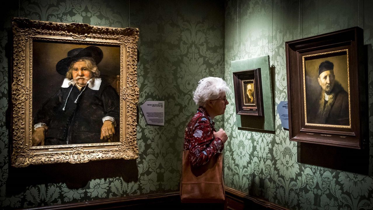 Una visitante a la muestra, entre dos de las 18 obras incluidas en la exposición