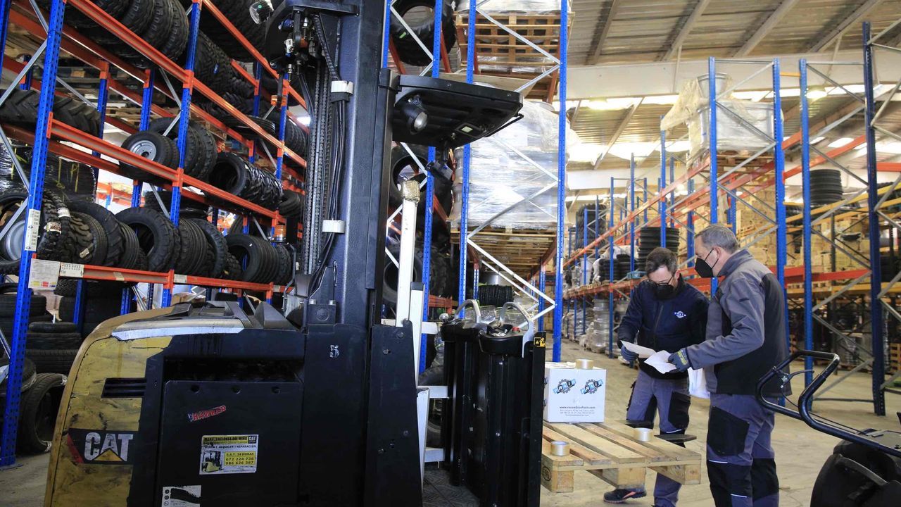 Algunos trabajadores de las naves dañadas preparan pedidos en la parte del pabellón que se salvó
