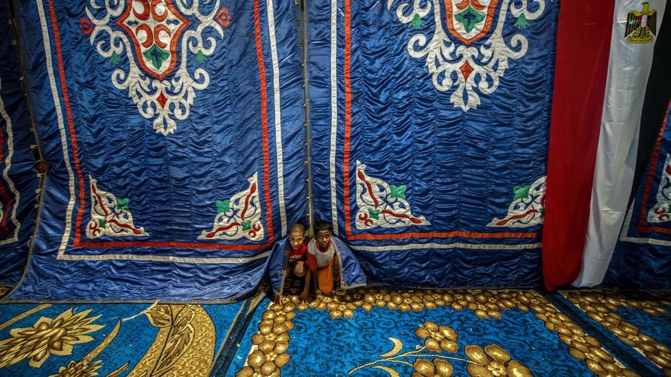Unos niños egipcios juegan detrás de tiendas de lona durante un mítin de campaña para la coalición «Por el amor de Egipto».
