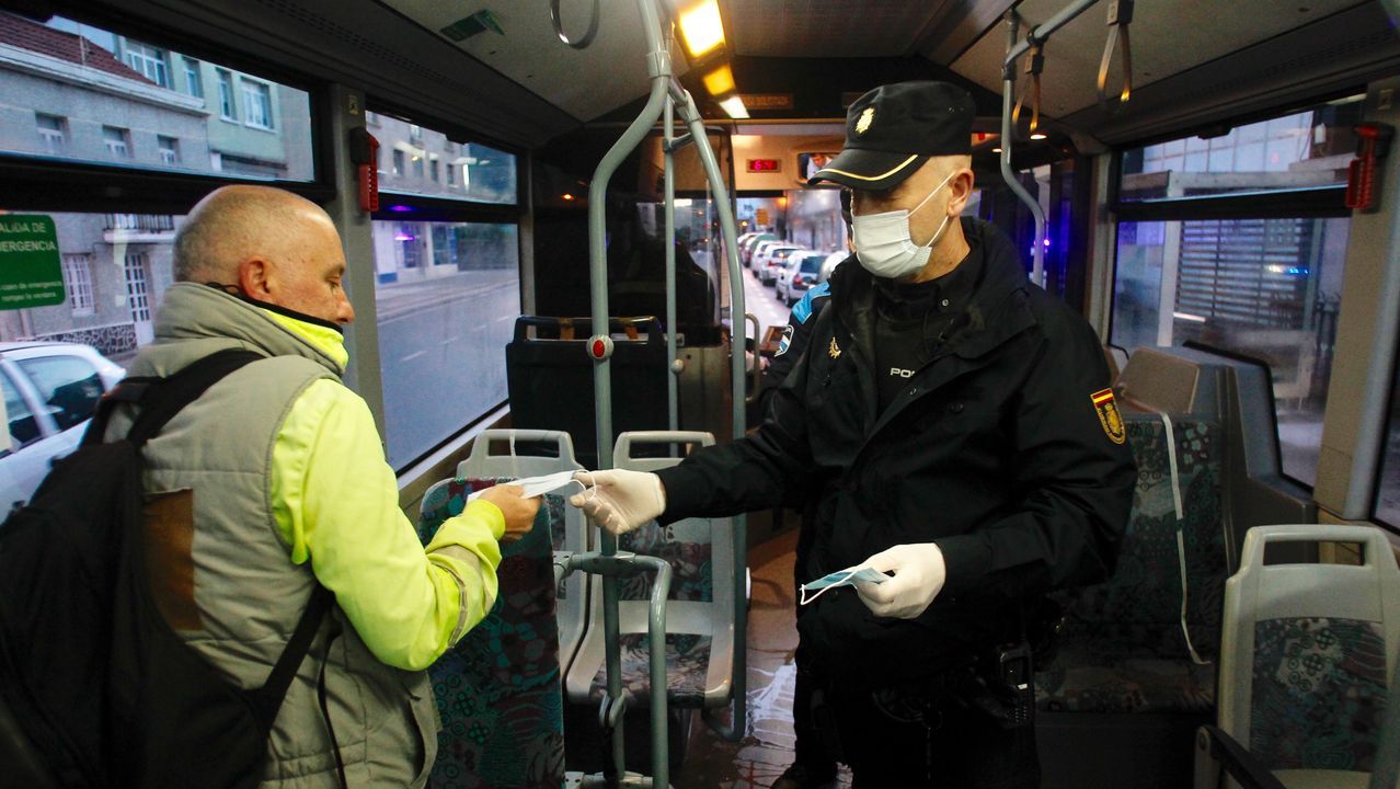 Policia local de Narón y Policía Nacional reparten mascarillas a usuarios del transporte público urbano en la carretera de Castilla en O Alto
