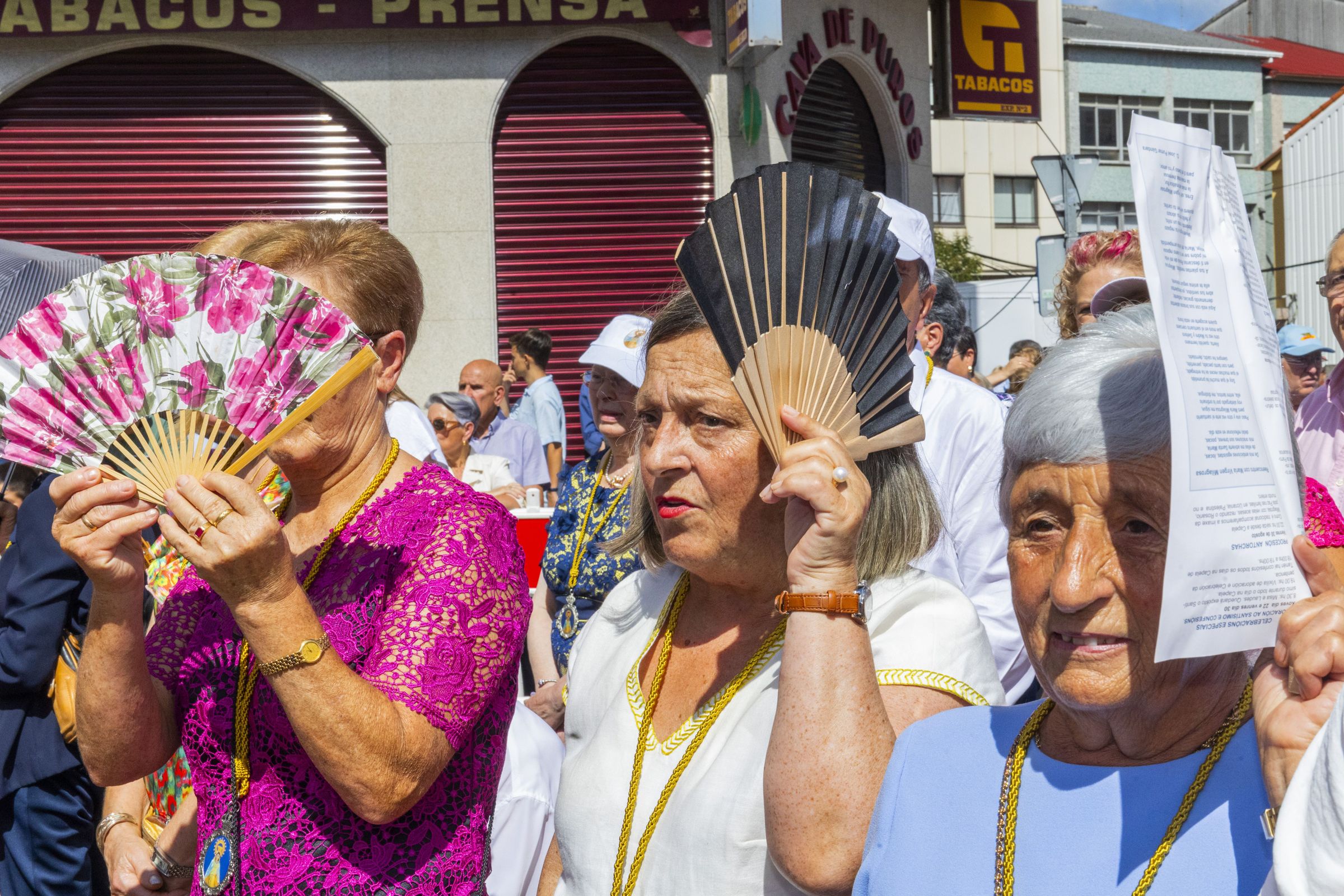 Devotas protxense do sol cos seu abanicos durante a misa nas festas da Milagrosa en Carballo. 1/09/2024
