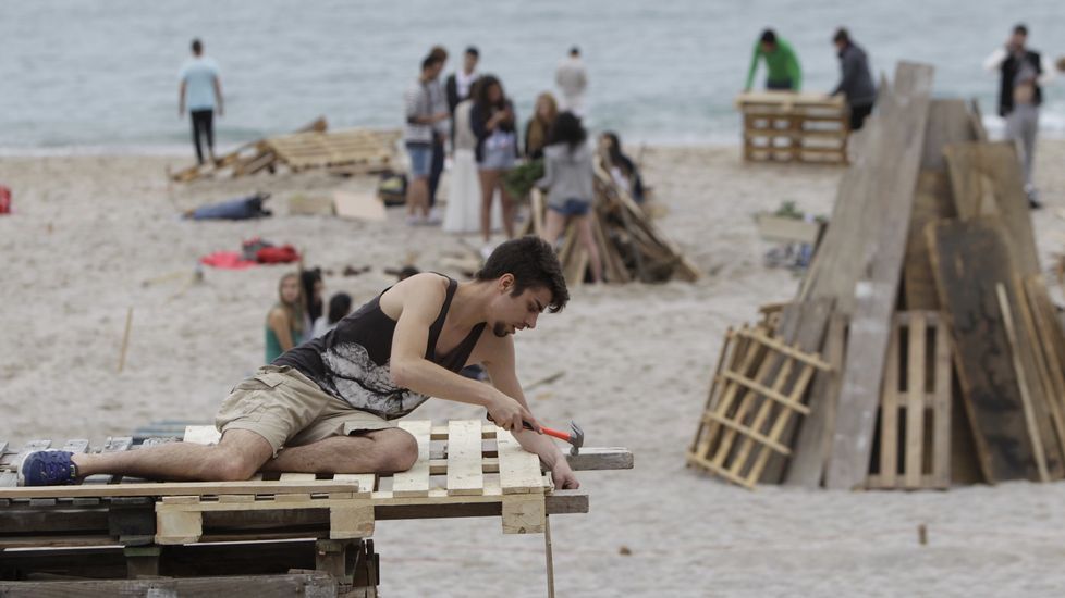 Un chico montando su hoguera de San Juan