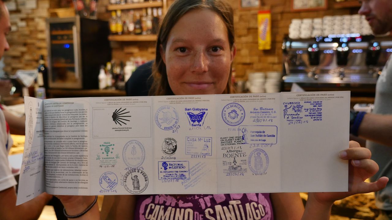 Julia nos enseña su credencial llena de sellos en Arzúa