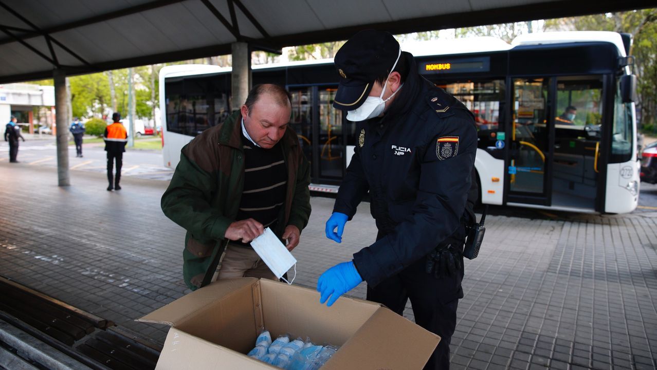 Policía Local y Nacional reparten mascarillas a los usuarios de los autobuses en Pontevedra