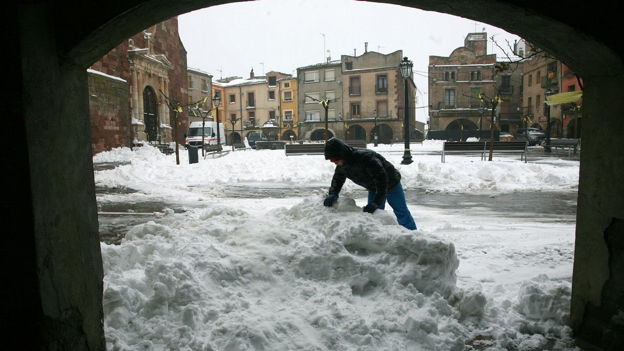 Un vecino retira nieve en la Pl Major de Prades (Tarragona)