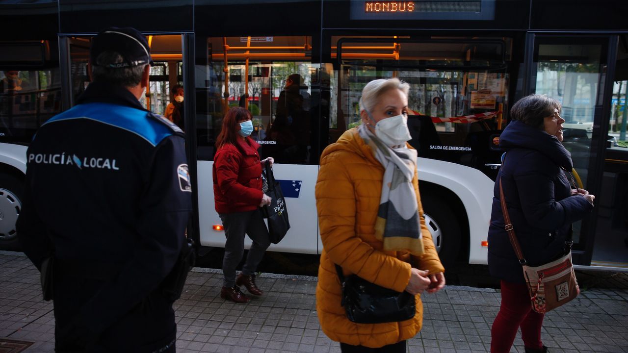 Policía Local y Nacional reparten mascarillas a los usuarios de los autobuses en Pontevedra