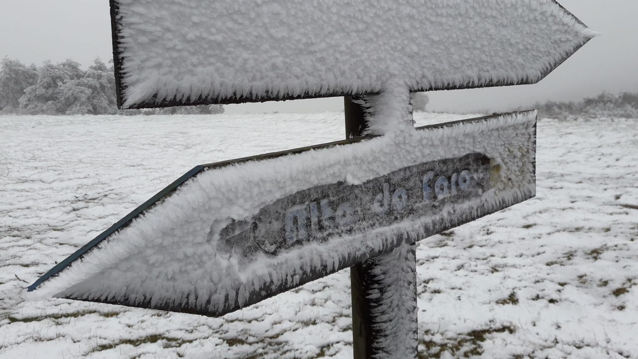 Una señal de tráfico cubierta de nieve este lunes por la mañana en el acceso al monte Faro (Chantada)