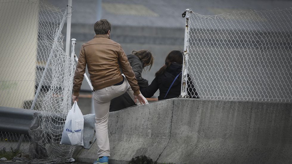 GENTE CRUZANDO LA MEDIANA DE LA CARRETERA BAÑOS DE ARTEIXO. ZONA DE MARINEDA CITY