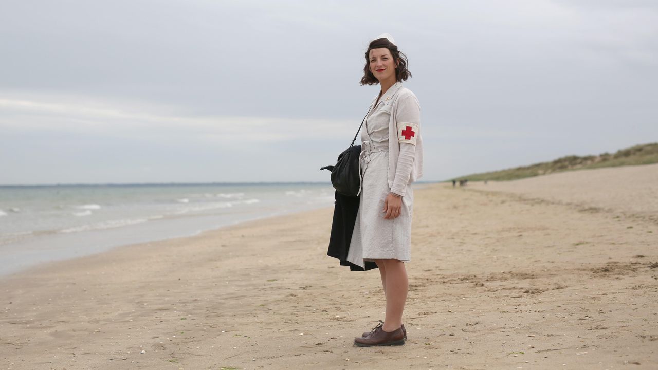 Una mujer vestida de enfermera de la época visita la histórica playa de Utah, en la costa de Normandía