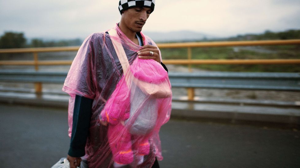 Un emigrante porta a su bebé mientras camina para coger un autobús que cruzará la frontera entre Grecia y Macedonia.