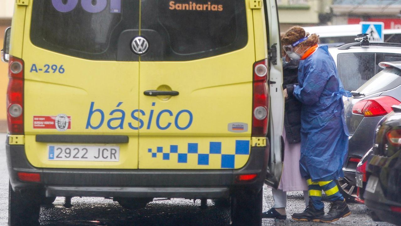 Ambulancia recogiendo a una mujer mayor en su domicilio en el centro de Ferrol
