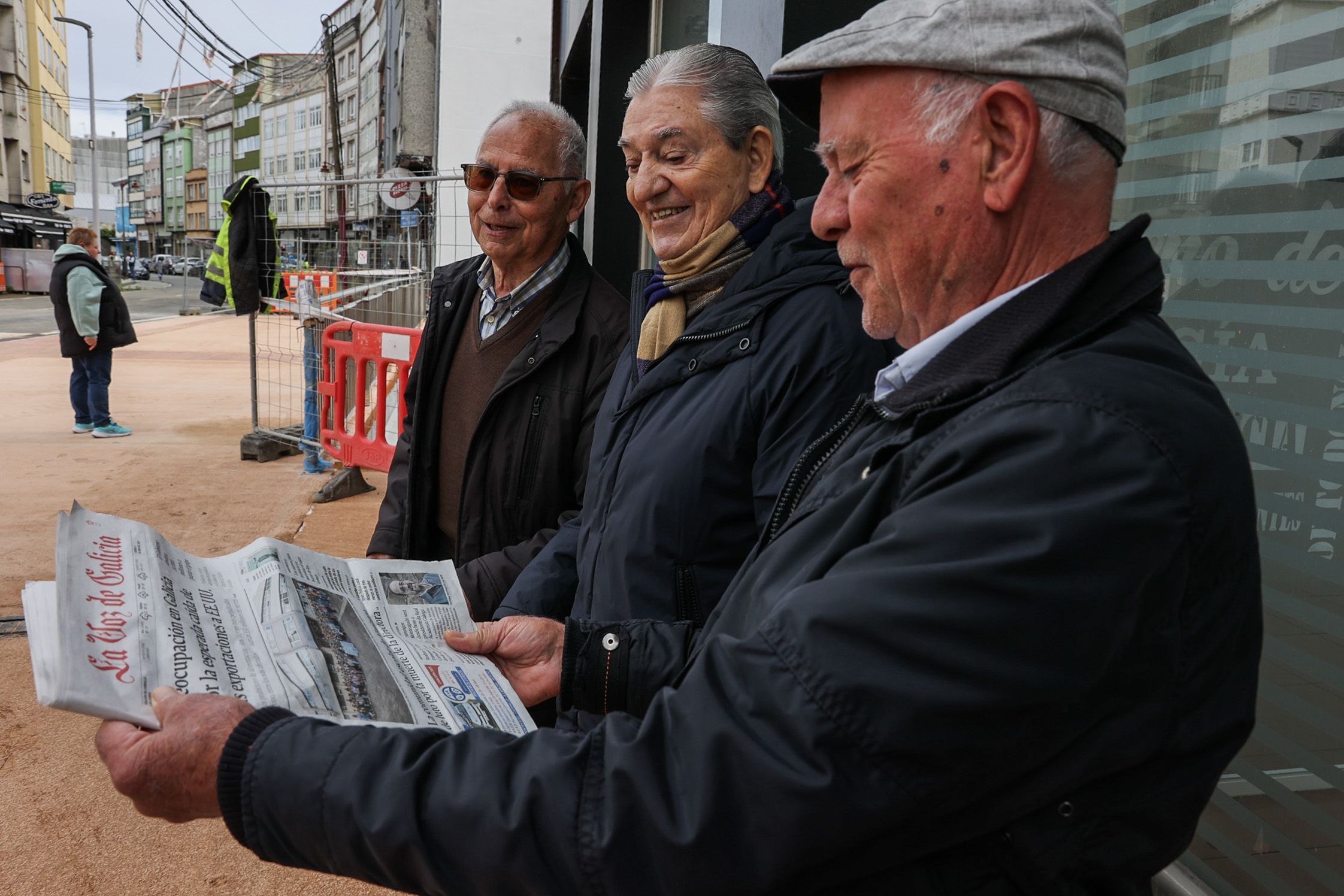 Varios vecios con La Voz de Galicia na mau mentras esperan a apetura da ponte da ra Fomento, en Carballo, que se atopaba en obras. 04/04/2025