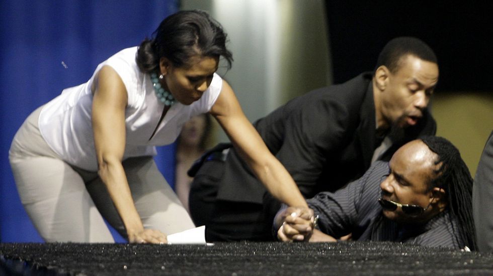 Por una lista de Spotify de su marido sabemos que Michelle Obama es una gran fan de Stevie Wonder. En esta ocasión, y de nuevo por culpa de unas escaleras, Michelle y Stevie acabaron por el suelo durante un acto político celebrado en California en el año 2008