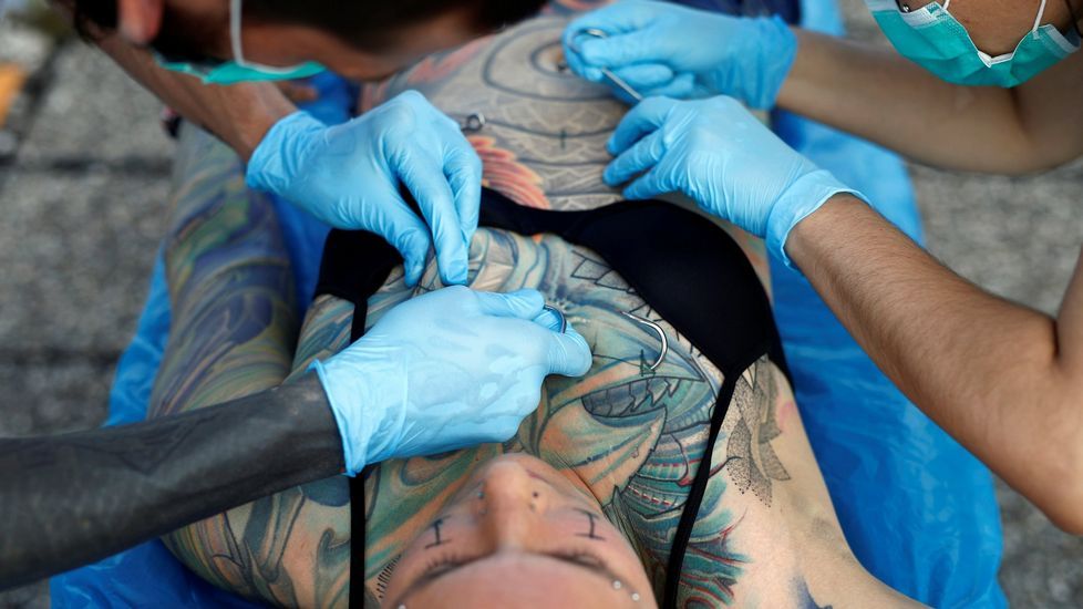 Utilizan agujas para perforar la piel de Kaitlin, que será «colgada» por ganchos sujetos de poleas