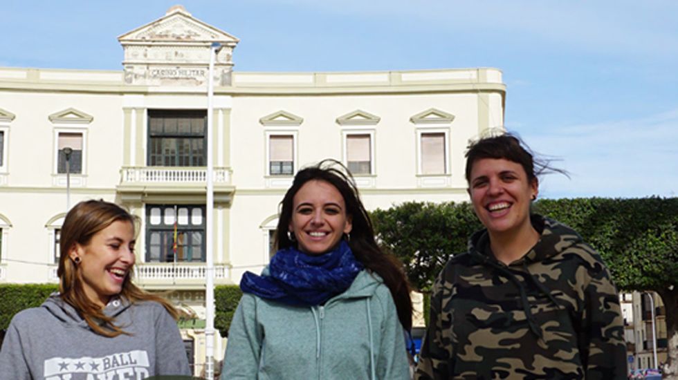 Voluntarias de Harraga en un fragmento del cartel retirado de las calles de Gijón