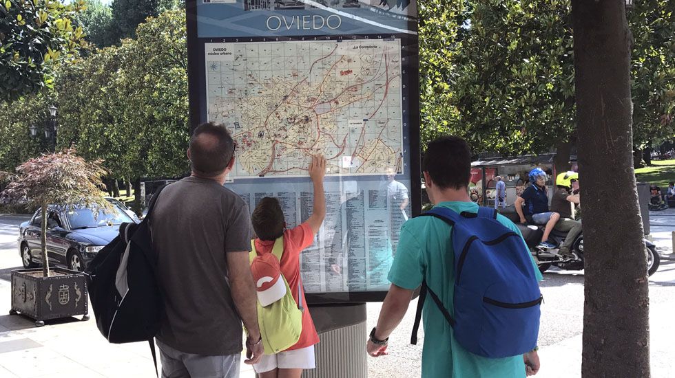 Unos turistas consultan un plano de Oviedo en la calle Uría