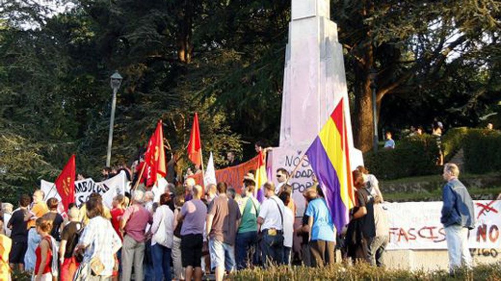 Manifestantes protestan frente a una cruz franquista.