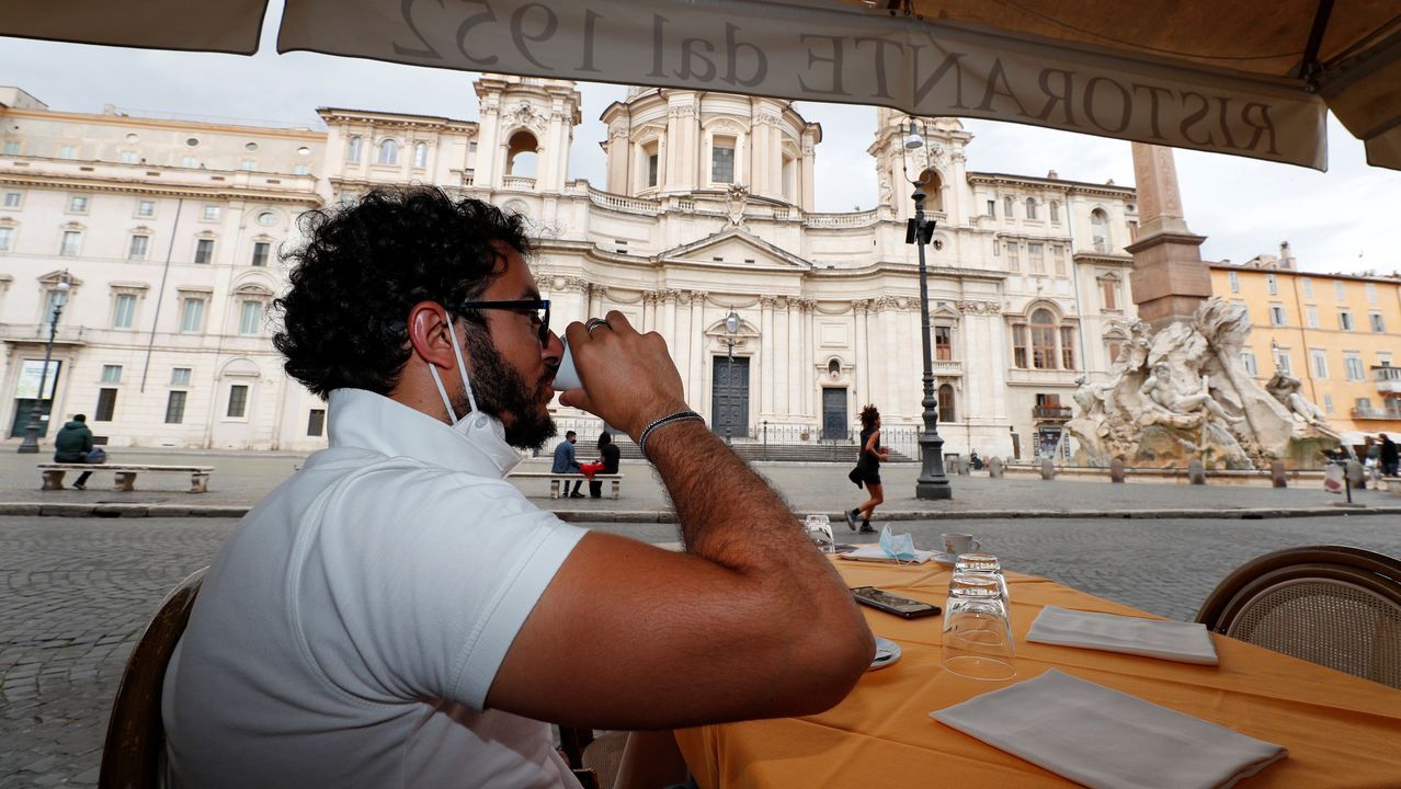 Un hombre toma un café en la Piazza Navona de Roma