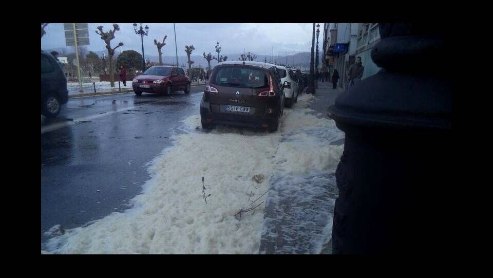 La arena arrastrada por el mar cubre los coches aparcados en el centro de Baiona